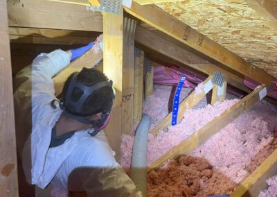 attic insulation contractor working in an attic with blow in insulation